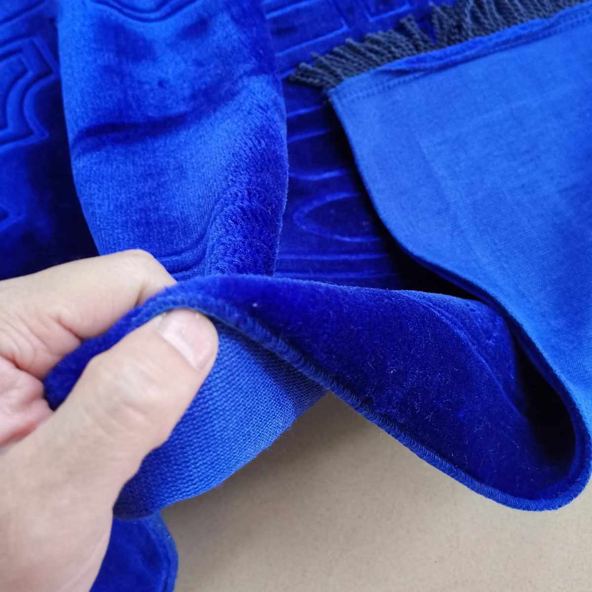 Gros plan sur le velours bleu roi du tapis de prière turc plié à la main